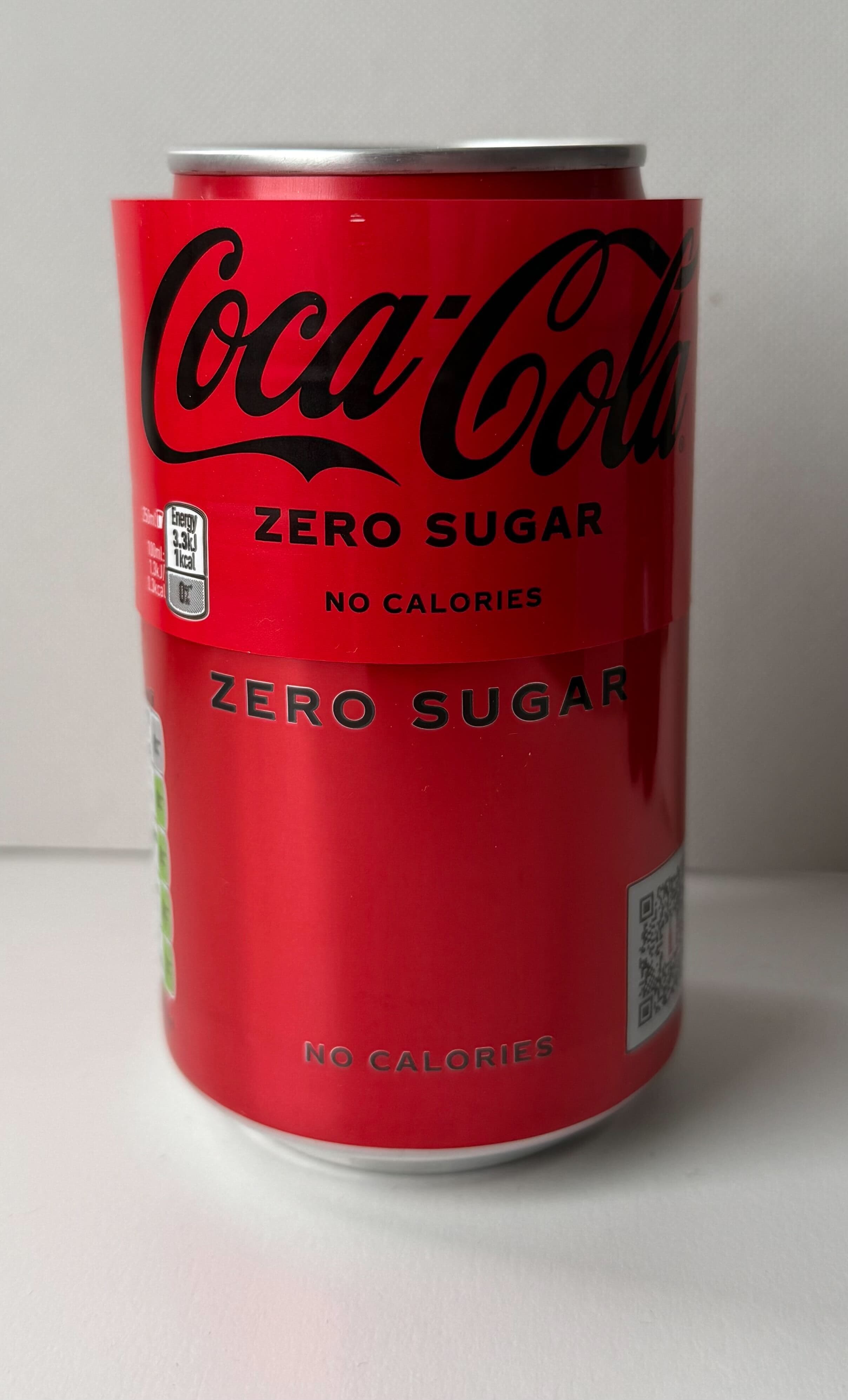 Metal can with plastic label overlaid